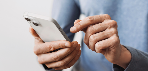 AdobeStock_615090308 スマホを触っている様子